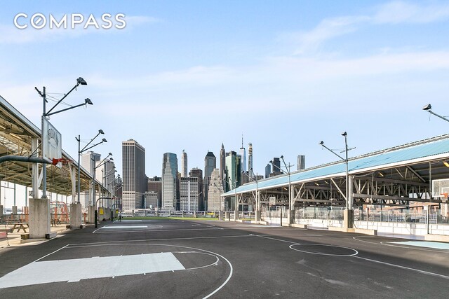 view of sport court featuring a view of city and fence