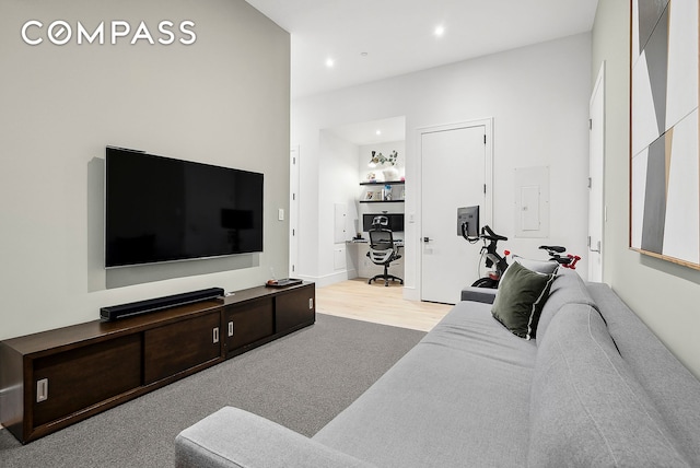 living room with wood finished floors, electric panel, and recessed lighting