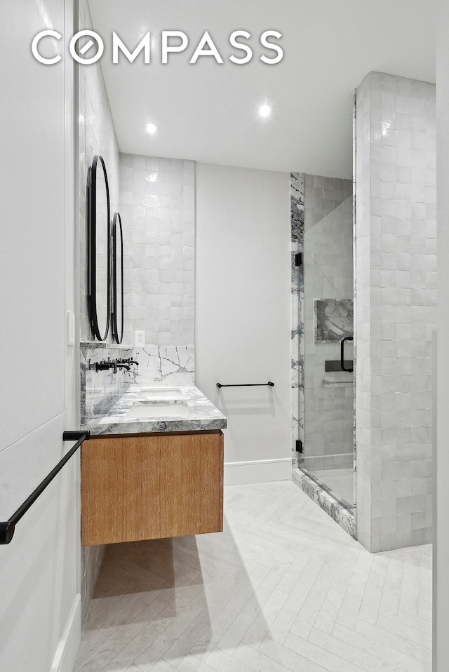 full bath featuring a stall shower, vanity, baseboards, and recessed lighting