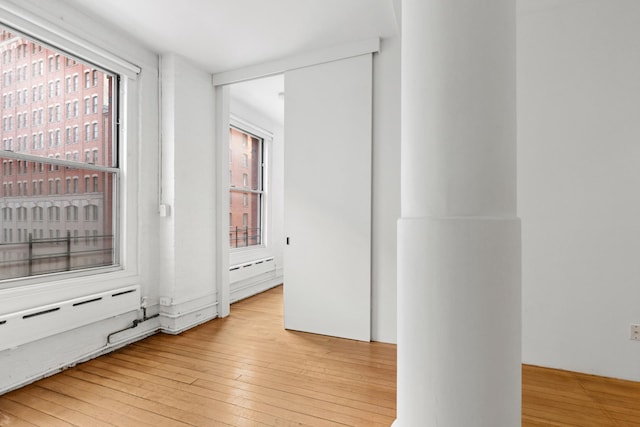 hallway with baseboard heating and hardwood / wood-style flooring