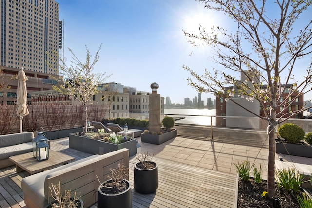 deck featuring a water view, an outdoor hangout area, fence, and a view of city