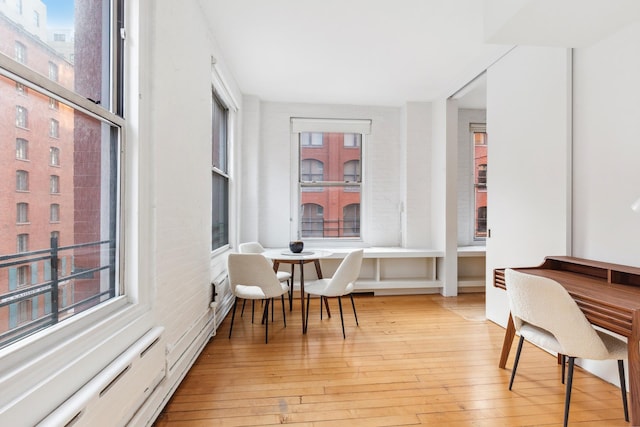 office area featuring light wood-style floors and a baseboard heating unit