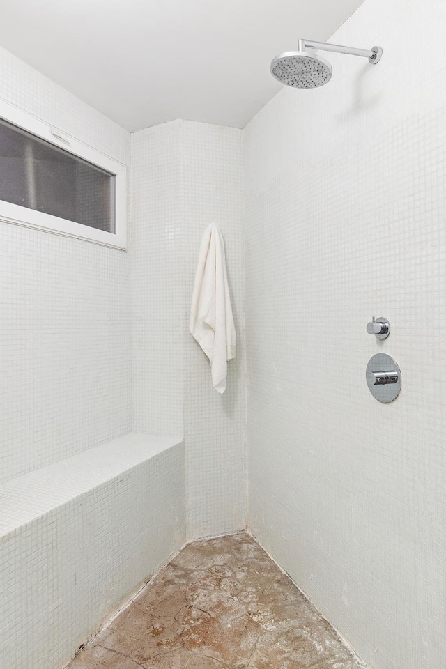 full bath featuring tiled shower and unfinished concrete floors