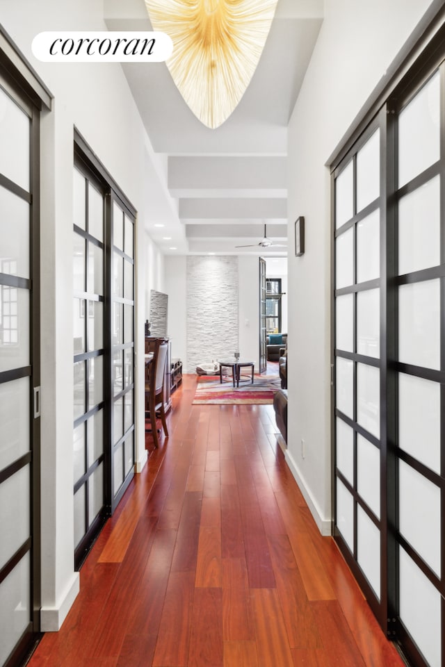 corridor featuring french doors, baseboards, and wood-type flooring