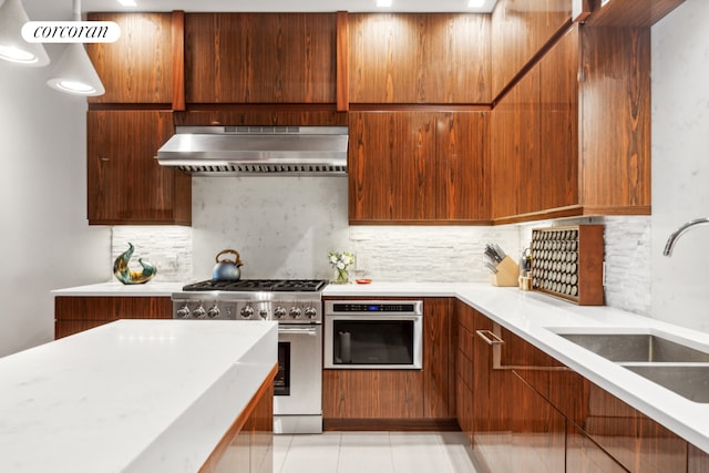 kitchen featuring a sink, tasteful backsplash, range hood, appliances with stainless steel finishes, and light countertops