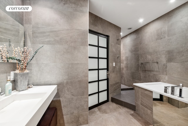 full bathroom featuring vanity, tile walls, a walk in shower, and tile patterned floors