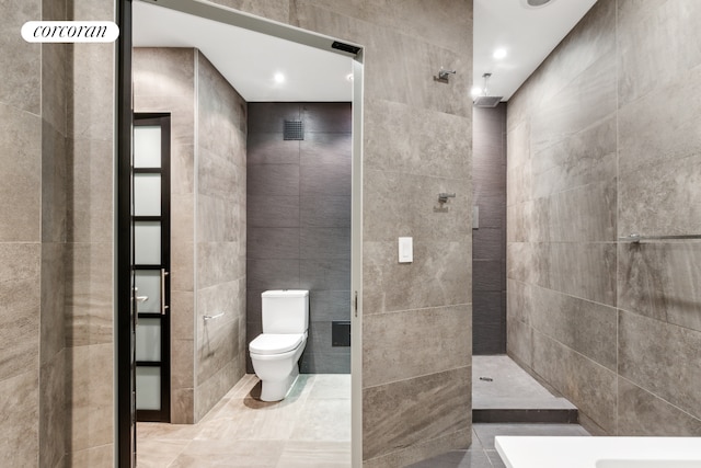 bathroom with tile walls, toilet, tile patterned floors, and walk in shower