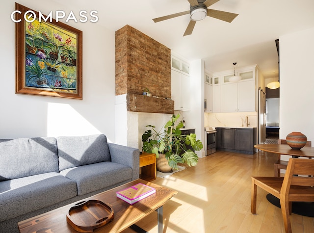 living room featuring light wood-type flooring and ceiling fan