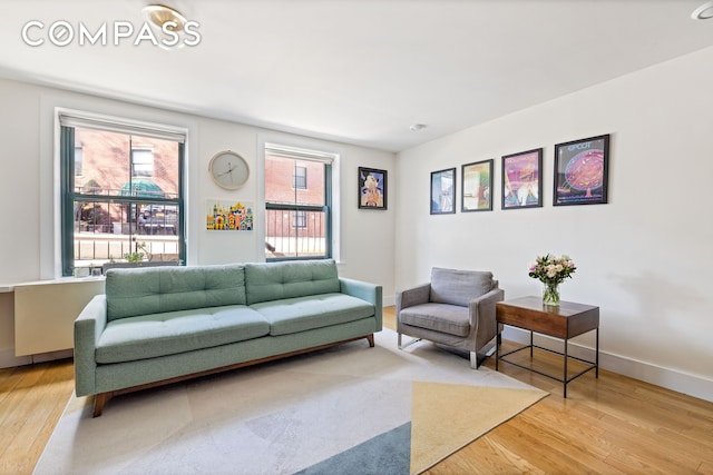 living area featuring light wood-style flooring and baseboards