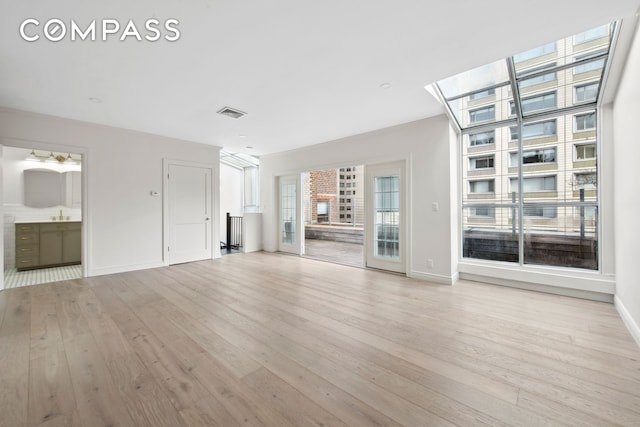 212 E 70th St Unit 4B, New York City, NY 10021 - unfurnished living room featuring light wood-style flooring, baseboards, and a sink