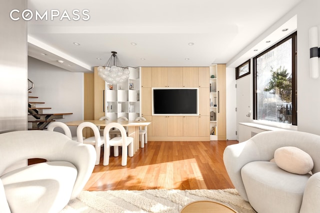 living room with a notable chandelier, recessed lighting, and light wood finished floors