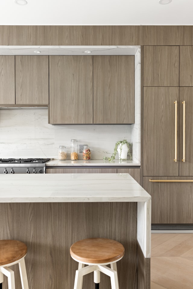 96 Coffey St, New York City, NY 11231 - kitchen featuring a breakfast bar, modern cabinets, and light stone counters