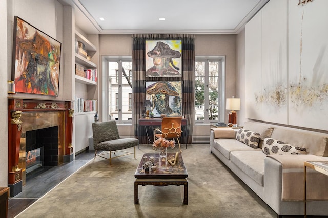living area featuring built in features, a tiled fireplace, and plenty of natural light