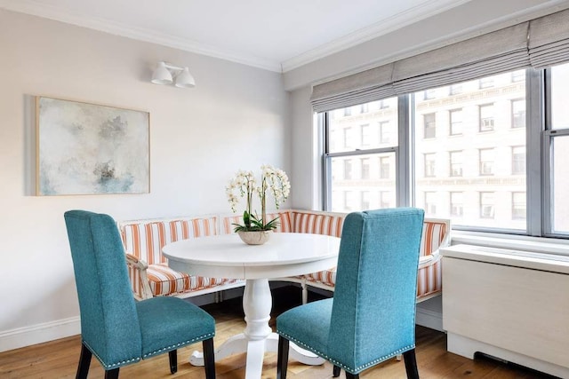 dining space with ornamental molding, wood finished floors, and breakfast area
