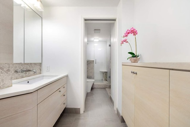 full bath featuring vanity, toilet, baseboards, a stall shower, and backsplash