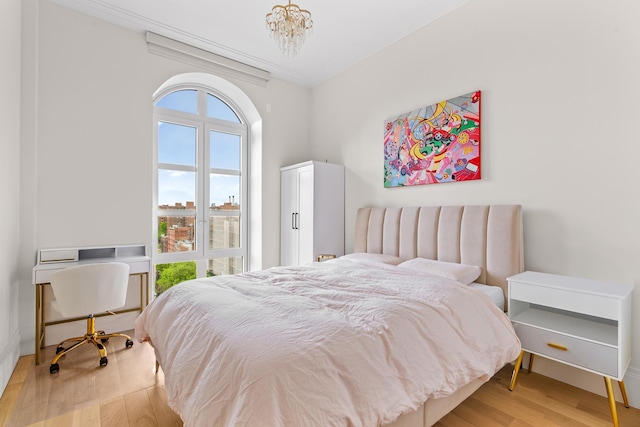 bedroom with light wood finished floors and a chandelier