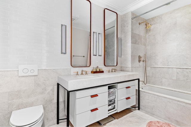 full bathroom featuring double vanity, ornamental molding, tile walls, toilet, and tiled shower / bath