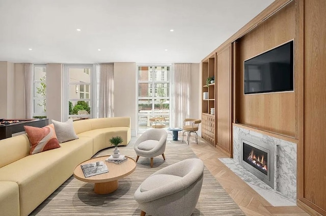 living room featuring a wall of windows, a premium fireplace, and recessed lighting