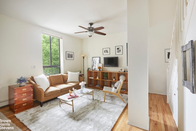 living area featuring a baseboard radiator, light wood-style flooring, and ceiling fan