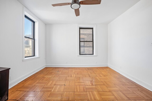 unfurnished room with ceiling fan and baseboards