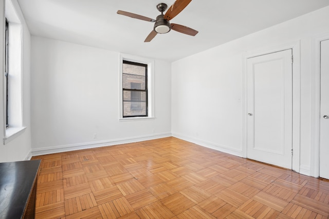 unfurnished room featuring ceiling fan and baseboards