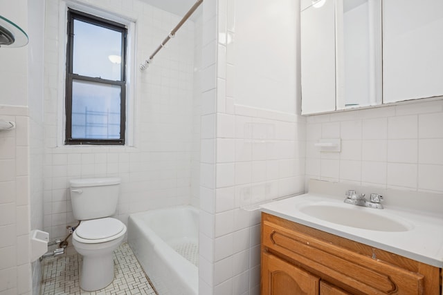 full bathroom with toilet, vanity, tile walls, and tile patterned floors