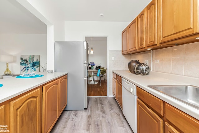 3840 Greystone Ave Unit 5L, New York City, NY 10463 - kitchen featuring dishwasher, freestanding refrigerator, light wood-type flooring, light countertops, and tasteful backsplash