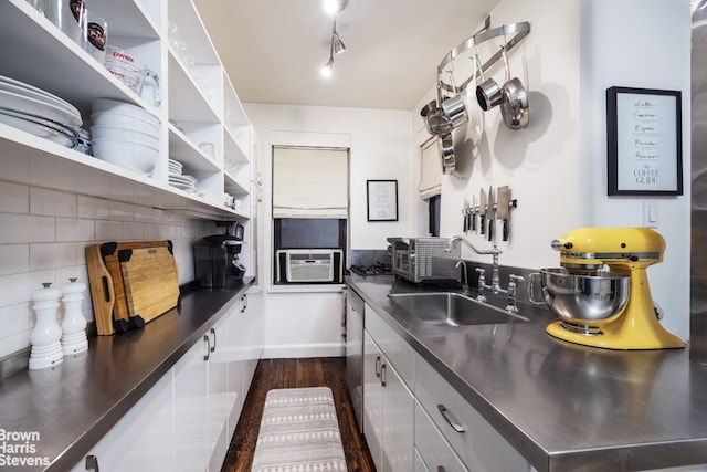 kitchen with dark wood-type flooring, a sink, stainless steel counters, backsplash, and open shelves