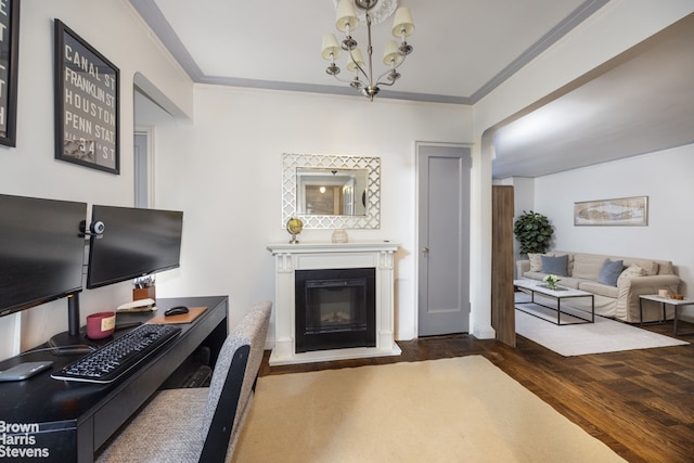living room with wood finished floors, a glass covered fireplace, an inviting chandelier, and crown molding