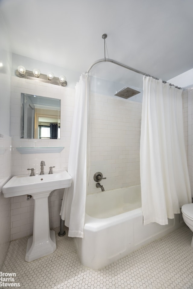 full bathroom with tile patterned flooring, toilet, shower / tub combo, and tile walls