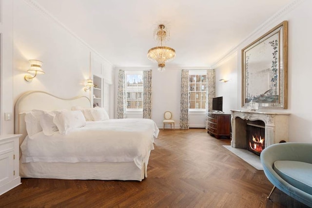 bedroom featuring a high end fireplace, ornamental molding, and a chandelier