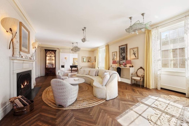 living area featuring a fireplace with flush hearth, ornamental molding, baseboards, and a chandelier