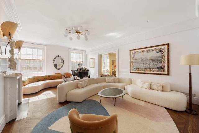 living area with ornamental molding, baseboards, and a chandelier