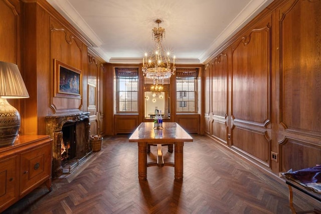 dining room featuring a chandelier, a fireplace, and crown molding