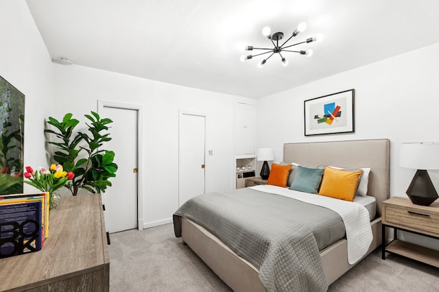 bedroom with a notable chandelier and light colored carpet