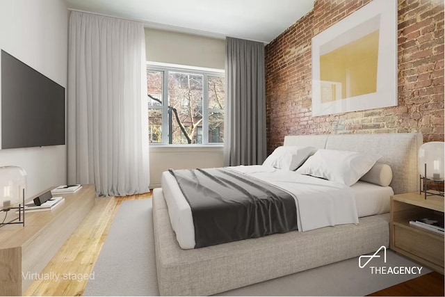 bedroom featuring brick wall and wood finished floors