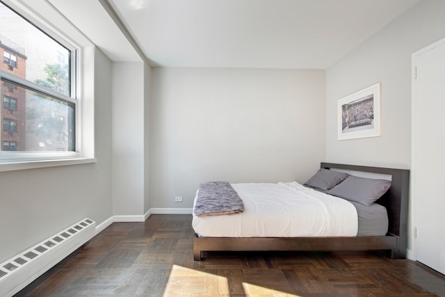 bedroom with a baseboard heating unit and baseboards