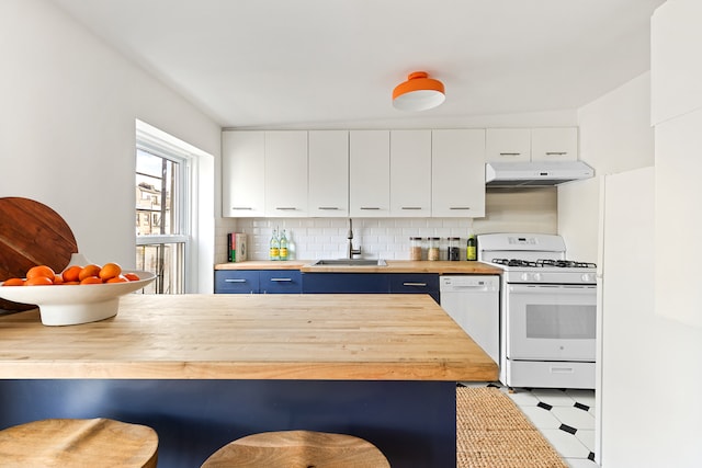 kitchen with blue cabinetry, butcher block counters, a sink, white appliances, and under cabinet range hood