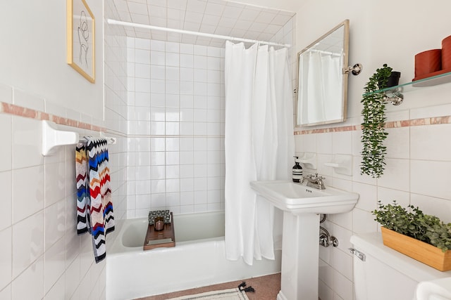 full bathroom featuring toilet, shower / bath combo, a sink, and tile walls