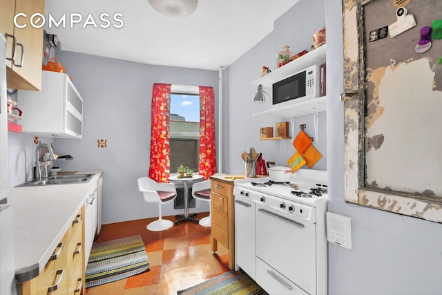 kitchen with open shelves, white cabinets, a sink, white appliances, and tile patterned floors