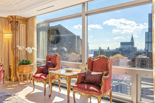 sitting room with ornamental molding, a city view, and plenty of natural light