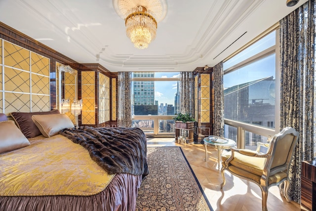 bedroom with ornamental molding, an inviting chandelier, a tray ceiling, a city view, and floor to ceiling windows