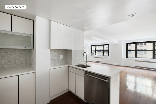 kitchen featuring light countertops, visible vents, a sink, dishwasher, and a peninsula