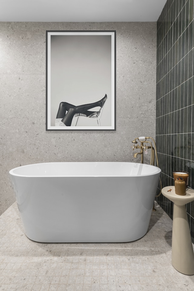 full bath featuring tile walls and a freestanding tub