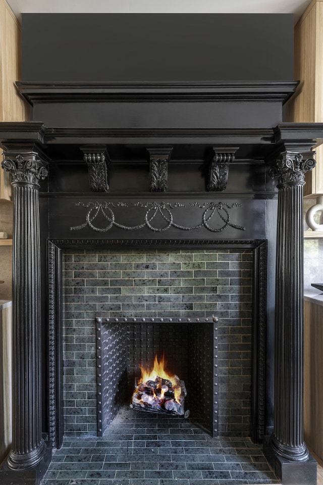 interior details featuring ornate columns and a tile fireplace