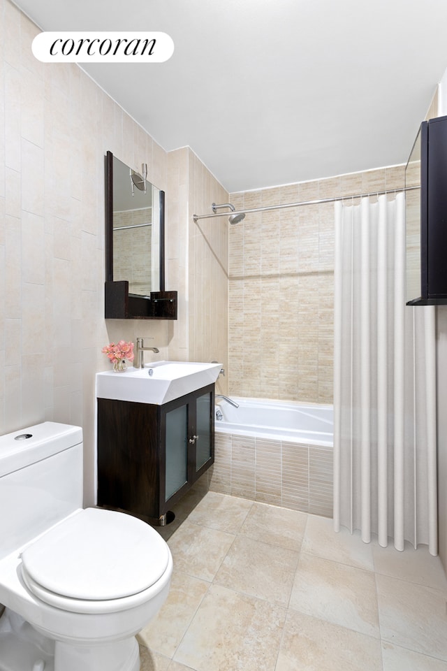 full bathroom featuring tiled shower / bath combo, toilet, tile walls, and vanity