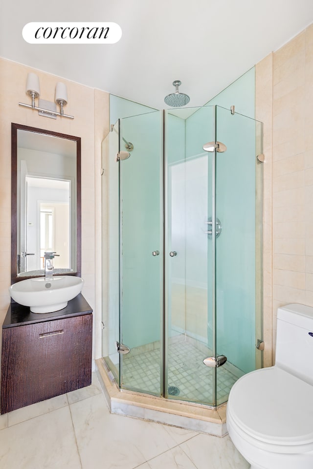 full bath with vanity, a stall shower, and toilet