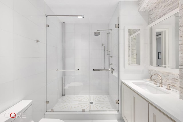 bathroom with tasteful backsplash, a shower stall, toilet, and vanity