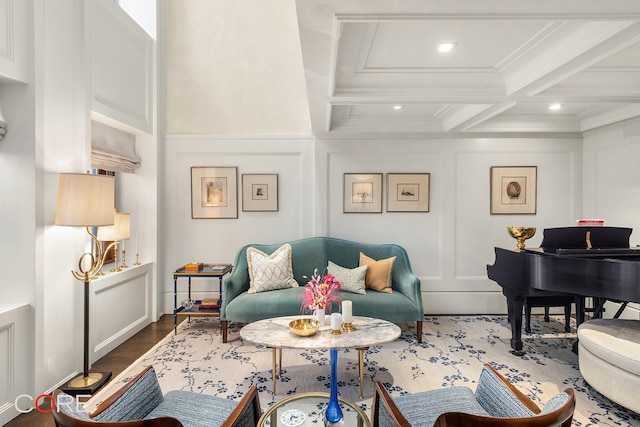 living area with coffered ceiling, wood finished floors, beamed ceiling, a decorative wall, and crown molding