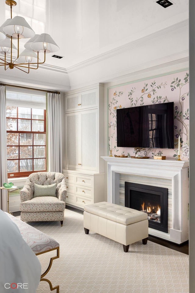 sitting room with carpet floors, visible vents, an inviting chandelier, ornamental molding, and a lit fireplace